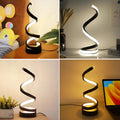 Helix Glow Table Lamp on a desk, side-emission light glowing along the curve