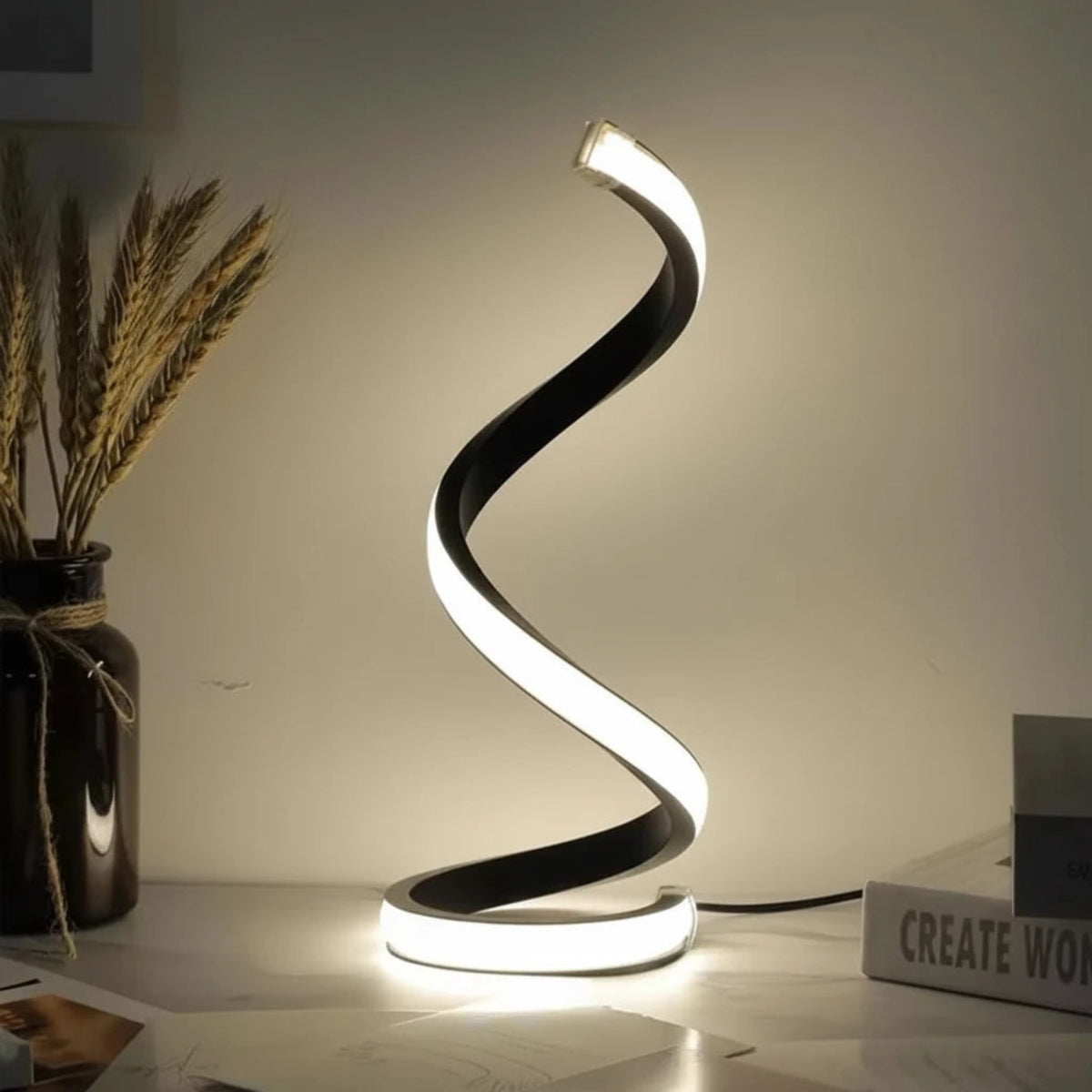 Helix Glow Table Lamp lit on a bedside table, warm light tracing its curved form