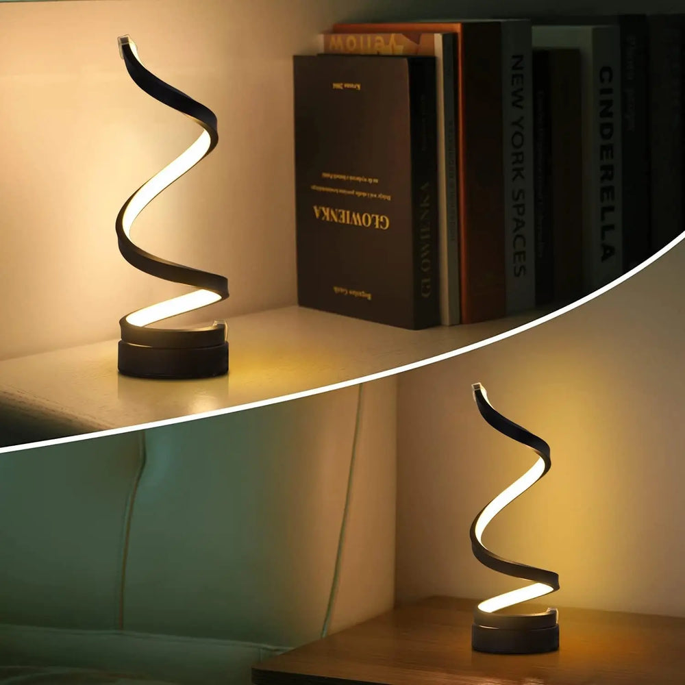 Helix Glow Table Lamp switched on beside a plant, showing its sculptural spiral silhouette